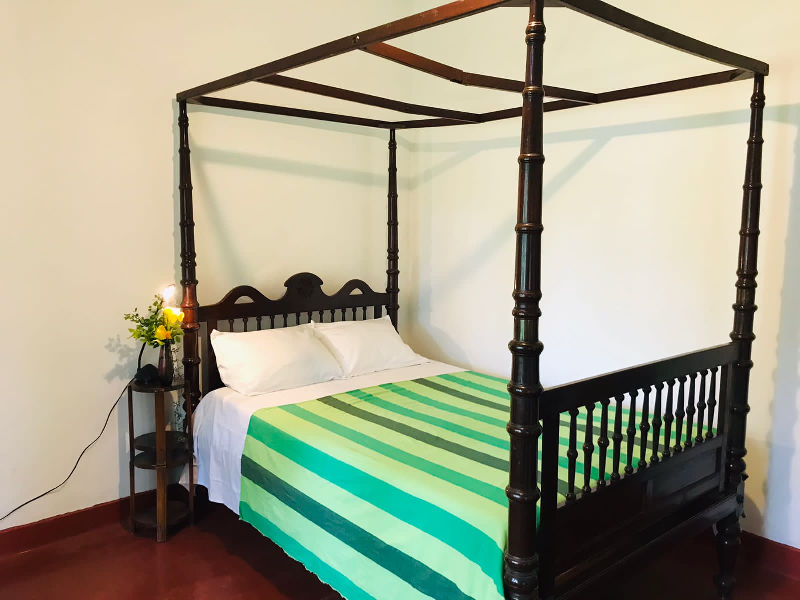 Four-poster bed in guest room at Lion Shade Bungalow
